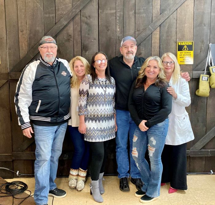 Group of six people smiling indoors.