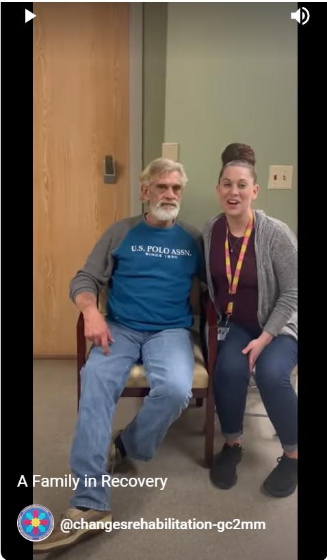 Man and woman sitting, smiling together.