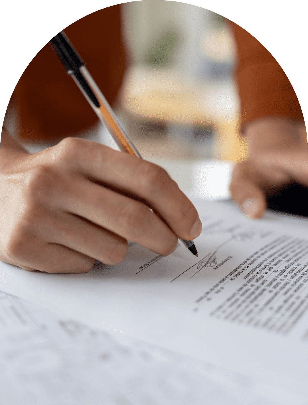 Hand signing a document with pen.