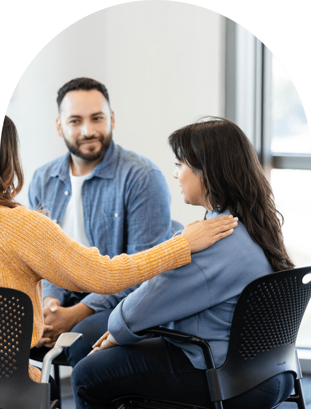 Support group meeting with comforting gesture.