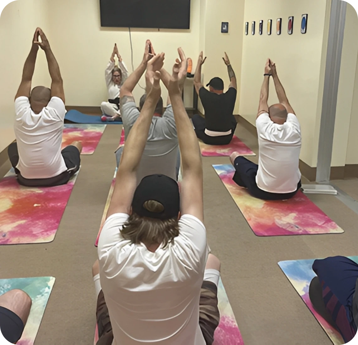 People practicing yoga in a classroom setting.