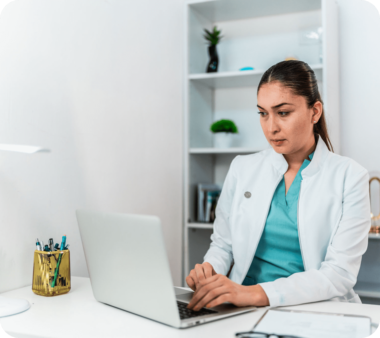 Doctor working on a laptop at desk.