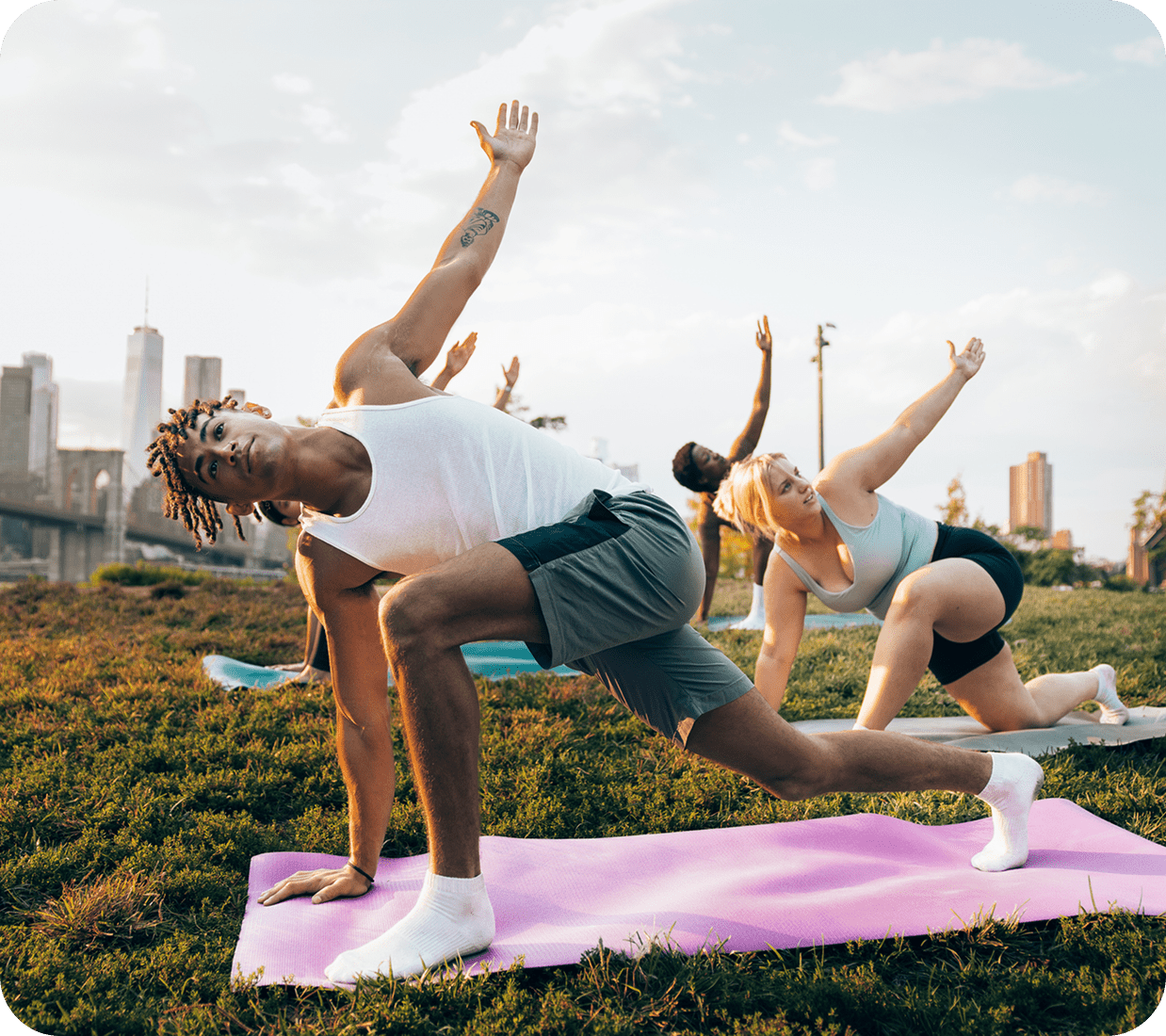 People doing yoga outdoors on mats.