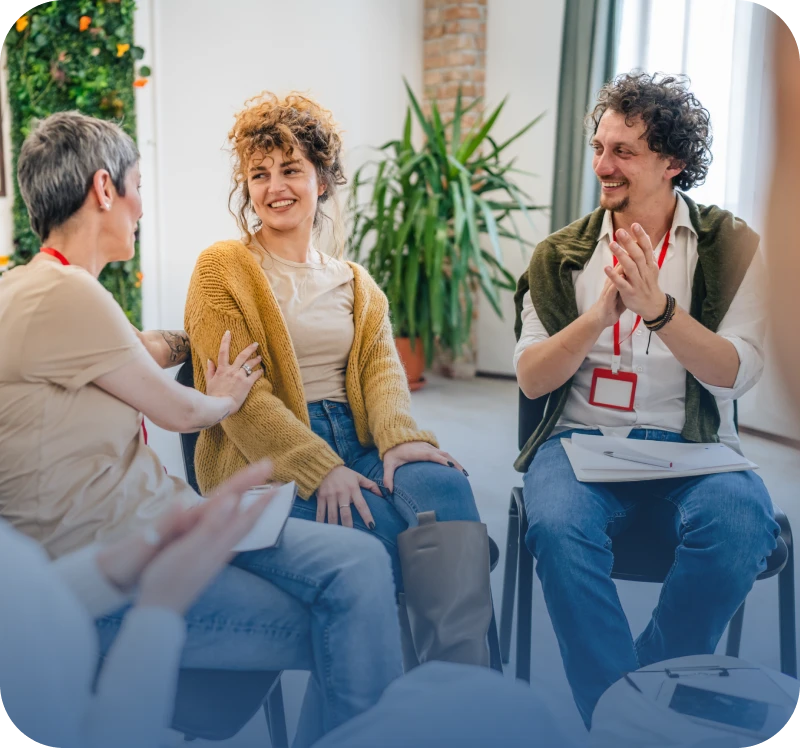Group discussion with people smiling and clapping.