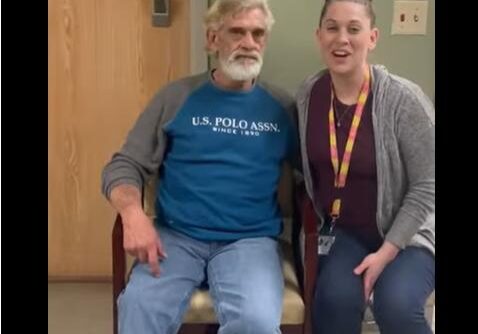 Man and woman sitting, smiling together.